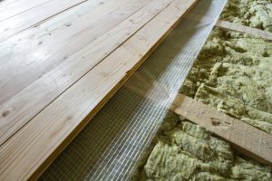 Installation of new floor of wooden natural planks and mineral wool insulation for isolation
